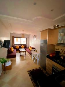 een woonkamer met een bank en een tafel bij Comfort apartment, with nice terrace (2min to sea) in Aourir