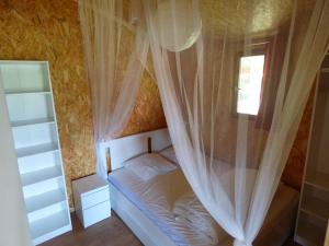 a bedroom with a bed with curtains and a window at Le Carbet Vendéen in Bouillé-Courdault +31 photos