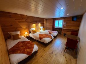 1 dormitorio con 2 camas en una cabaña de madera en Hôtel du Centre en Valloire