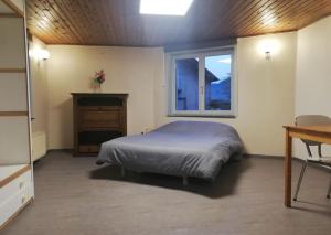 1 dormitorio con cama, ventana y escritorio en Au Vieux Gouvy en Gouvy