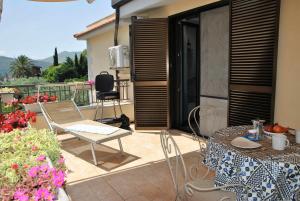 a patio with a table and chairs on a balcony at CASA DINKY Attico con terrazza vista mare in Formia