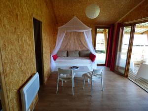 a bedroom with a bed with a canopy at Le Carbet Vendéen in Bouillé-Courdault