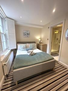 una camera da letto con un letto con un orsacchiotto sopra di Exquisite 3 Bedroom Apartment with Private Terrace in Pimlico a Londra