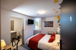 a hotel room with a bed and a bathroom at L'Auberge des Artistes in Nieul-sur-lʼAutise