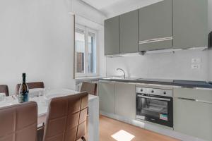 a white kitchen with a table and a stove top oven at -Centrale- Terrazza sul Lago, la brezza del Garda in Desenzano del Garda