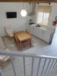 uma cozinha com uma mesa de madeira e um lavatório em Un Lugar Llamado Descanso en Monfrague em Torrejón el Rubio