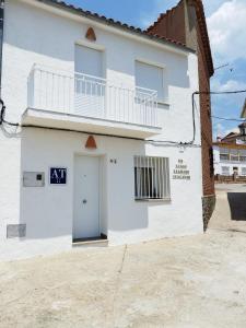 Edificio blanco con puerta y balcón en Un Lugar Llamado Descanso en Monfrague en Torrejón el Rubio
