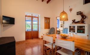 a kitchen and dining room with a wooden table and chairs at Casa can Pep Martí in Sant Francesc Xavier