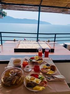 une table avec des assiettes de nourriture au-dessus d'un bateau dans l'établissement Hotel Kappa3 Villas, à Vlorë