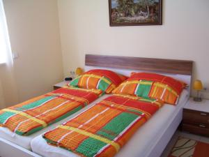 um quarto com 2 camas com cobertores e almofadas coloridos em LANDHAUS JASMIN ausgezeichnet mit 4 Kristallen - FW Kammblick em Bad Mitterndorf