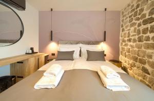 ein Schlafzimmer mit einem Bett mit zwei Kissen darauf in der Unterkunft Portella Rooms in Krk