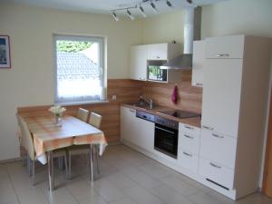 uma cozinha com uma mesa e um frigorífico branco em LANDHAUS JASMIN ausgezeichnet mit 4 Kristallen - FW Kammblick em Bad Mitterndorf