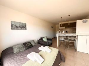 1 dormitorio con 1 cama y cocina con mesa en BettyStudio, cálido, centrico c/ vista a los Cerros en San Carlos de Bariloche