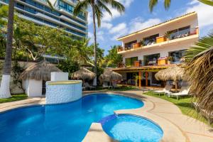 a resort swimming pool with a hotel in the background at Casa Mar&iacute;a Resort in Bucer&iacute;as