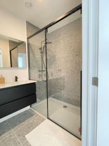 een badkamer met een glazen douche en een wastafel bij #2800ourhome 301 in Mechelen