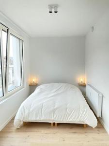 een witte slaapkamer met een bed en 2 ramen bij #2800ourhome 301 in Mechelen