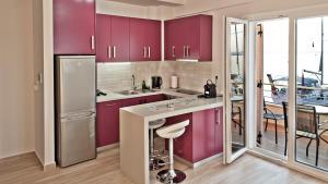 a kitchen with purple cabinets and a dining room at Sea Sparkle 1b in Preveza +43 photos