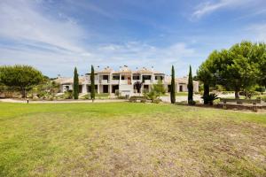 une grande maison avec une pelouse devant elle dans l'établissement Devvine Beach and Golf, à Alvor