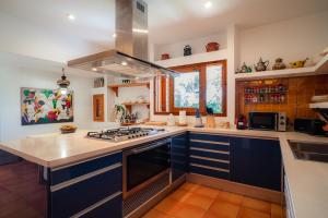 een keuken met blauwe kasten en een fornuis met oven bij Can Tamarix in La Savina