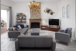 ein Wohnzimmer mit Sofas, einem TV und einem Kamin in der Unterkunft Casa Montelado in Mijas