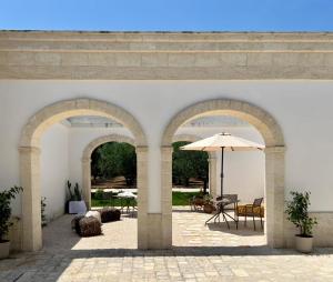 an archway with an umbrella in a courtyard at Casale Giuseppe in Fasano