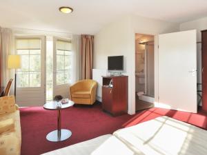 a hotel room with a bed and a television at Hotel De Brabantse Biesbosch in Werkendam