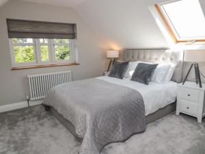a bedroom with a large bed and two windows at Willow Cottage in Morpeth