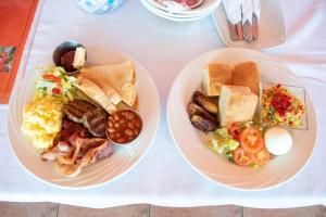 two plates of breakfast food on a table at La Heliconia & Day Spa in Saint Georgeʼs