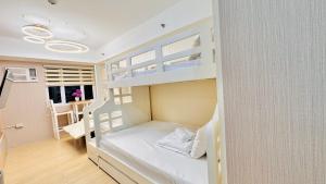 Zimmer mit Etagenbetten, einem Schreibtisch und einer Küche in der Unterkunft Cozy Staycation by Paris in Manila