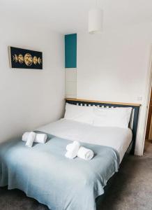 a bedroom with a bed with two towels on it at Stylish Open Plan City Apartment in Bath
