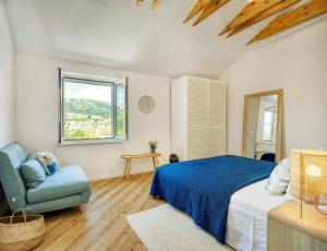 a bedroom with a bed and a chair and a window at House Gajarda in Rab