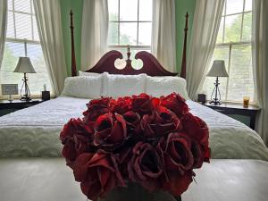 a bed with a pile of red roses on it at Winridge Manor in Madison Heights