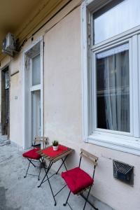 twee stoelen en een tafel voor een raam bij Bright & Shine Apartment in Boedapest