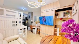 ein Wohnzimmer mit einem Sofa, einem TV und einem Tisch in der Unterkunft Cozy Staycation by Paris in Manila