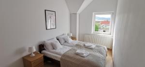 um quarto branco com uma cama e uma janela em Słoneczny apartament blisko jeziora i gór em Bielawa