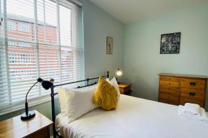 Historic Kelham House with FREE on-site Parking في شيفيلد: غرفة نوم عليها سرير ومخدة صفراء