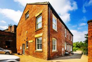 a brick building with a car parked in front of it at Historic Kelham House with FREE on-site Parking in Sheffield