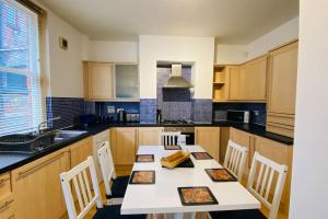 Historic Kelham House with FREE on-site Parking في شيفيلد: مطبخ مع طاولة وكراسي ومغسلة