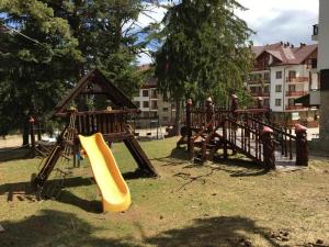 a playground with a slide in a park at Cozy Rila Park Apartments in Borovets