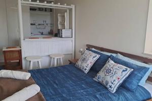 - une chambre avec un lit doté de draps et d'oreillers bleus dans l'établissement Ryans Surf Cabin, à Jeffreys Bay