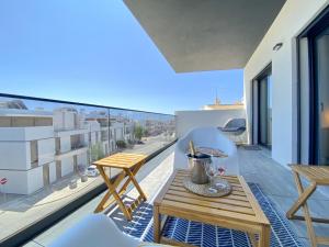 un patio con tavolo e sedie su un balcone di Tavira Grand Balcony With Pool by Homing a Tavira