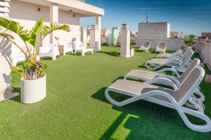 a row of chaise lounge chairs on a roof at Hotel Eden Mar in Guardamar del Segura