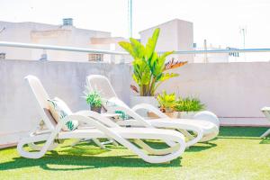 een groep witte ligstoelen op een balkon bij Hotel Eden Mar in Guardamar del Segura