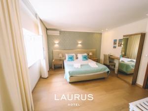 a hotel room with a bed and a window at Laurus Hotel in Lourinhã