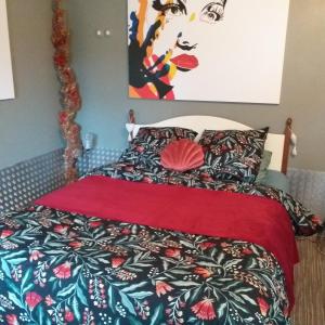 een slaapkamer met een bed met een rood dekbed bij The Annex in Saint-Maur-des-Bois