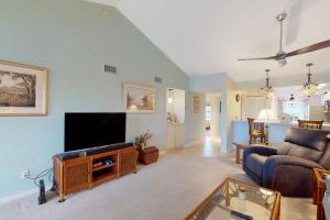 a living room with a couch and a tv at Sea-Renity, Unit H-205 in Naples