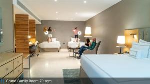 a hotel room with two dolls on the bed and people sitting in chairs at Grand Cosmopolitan Hotel in Dubai