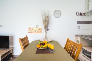 einen Tisch mit einer Schale Obst und Gläsern Orangensaft in der Unterkunft Charming flat with AC and balcony - Le Moule - Welkeys in Le Moule