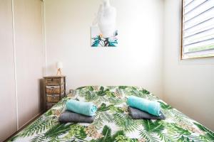 ein Schlafzimmer mit einem Bett mit zwei Kissen darauf in der Unterkunft Charming flat with AC and balcony - Le Moule - Welkeys in Le Moule