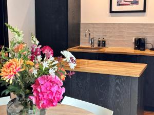 a vase of flowers on a table with a sink at Casa Clementine - Boutique Guesthouse in Veldhoven